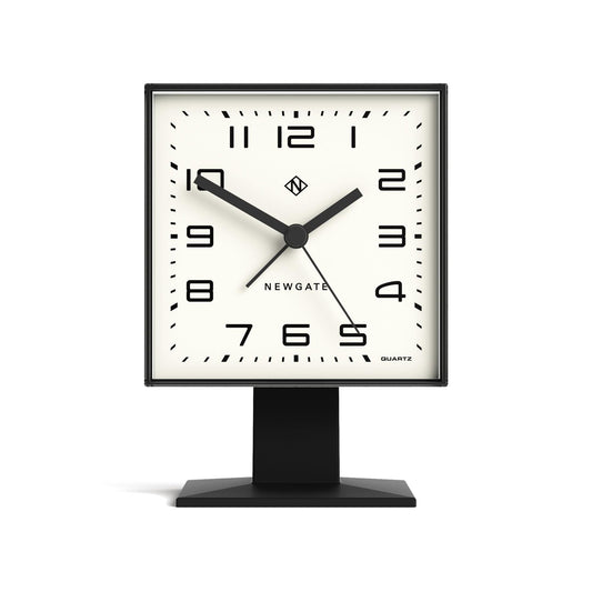 Black alarm clock with square white dial, analog hands, black base stand, front view