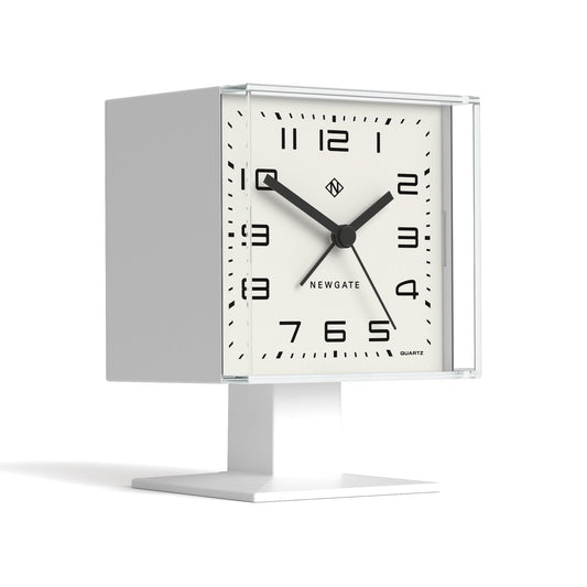 White square alarm clock with quartz dial and black hands on a desktop stand