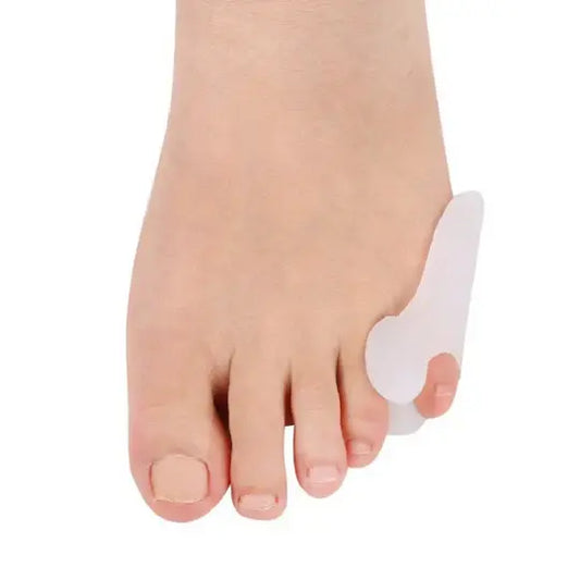 White bunionette toe spacer on pinky toe, worn on foot.