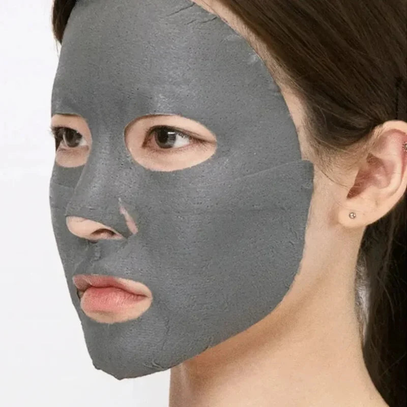 Charcoal-gray face mask sheet covering eyes and mouth on a woman