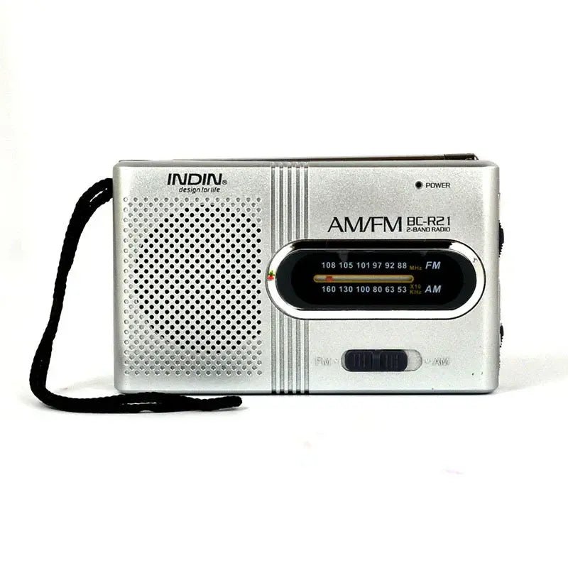Silver AM/FM portable radio with speaker grille and tuning dial, black shoulder strap.