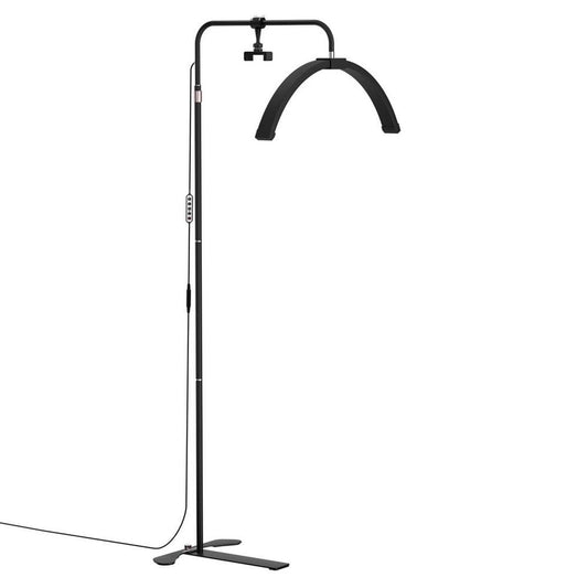 Standing LED half-moon beauty light with black metal frame and flat base.