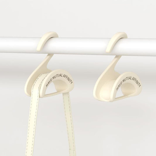 White set of bag hangers with curved hooks and stitched slots for handbag straps