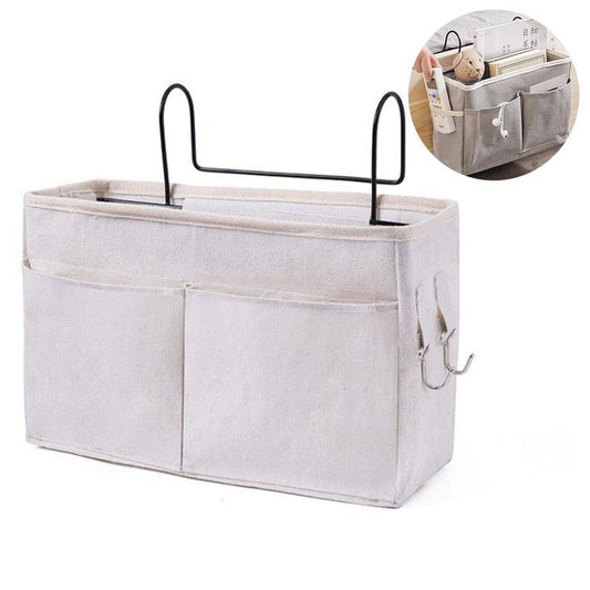 Light-colored hanging bed caddy with metal hooks and multi-pocket compartments