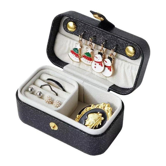 Black waterproof jewelry travel case open with ring tray and earring compartments