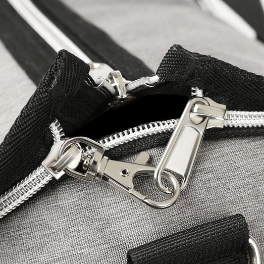 Zipper track with metal slider and hardware on a dark travel duffel bag