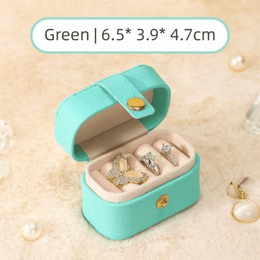 Mini jewelry travel case in teal, open to show ring compartments and padded insert