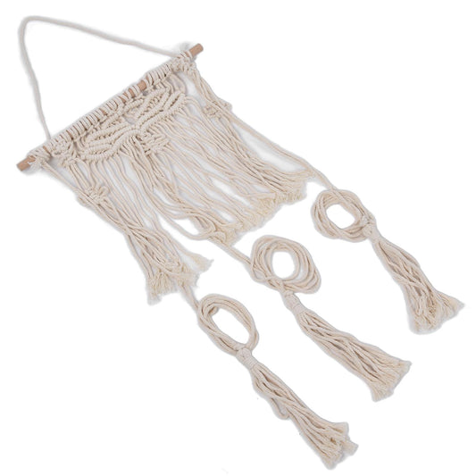 Off-white macramé hat wall hanging rack with hanging rope loops and tassels