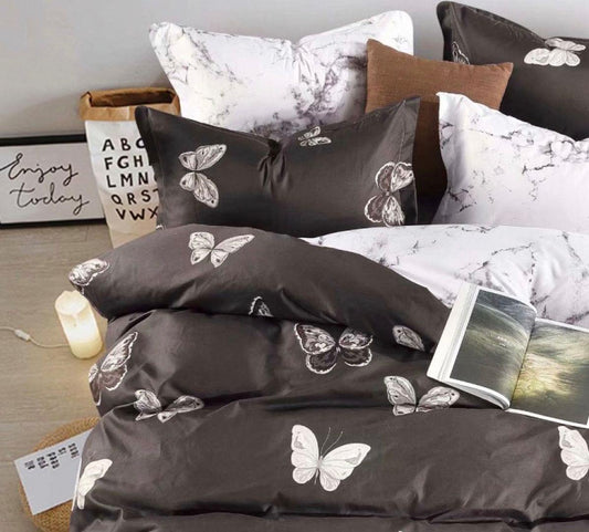 Butterfly duvet cover set with black cover, white butterfly print, and patterned pillows