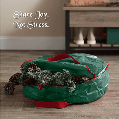 Green wreath storage bag with red straps, holding a decorated artificial wreath