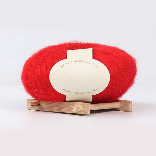 Boovnll mohair yarn skein in bright red on wooden plank with cream label
