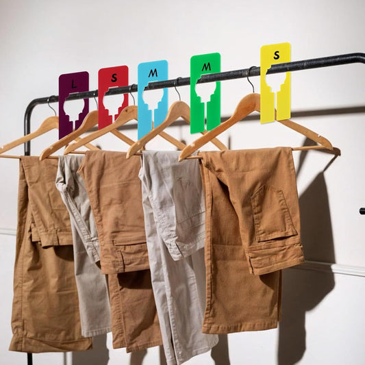 Plastic closet rack dividers on a clothing bar, size labels L, S, M in color