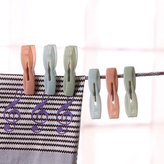 Plastic clothes pegs, pastel orange, gray, sage, and green clips on line