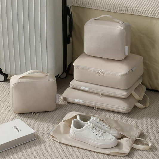 Beige compression packing cubes folded stack with top handles and zippers