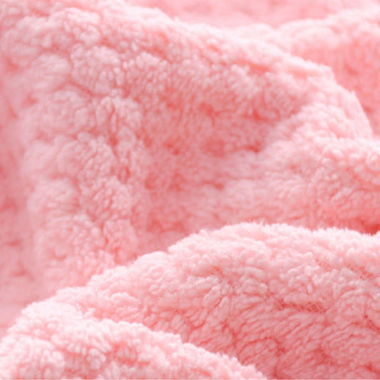 Pink plush bath towel fabric close-up with dense pile texture
