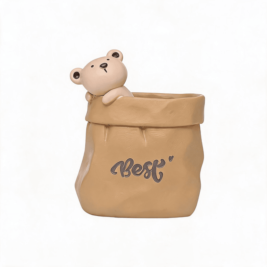 Tan resin paper-bag pen holder with small bear figurine on top