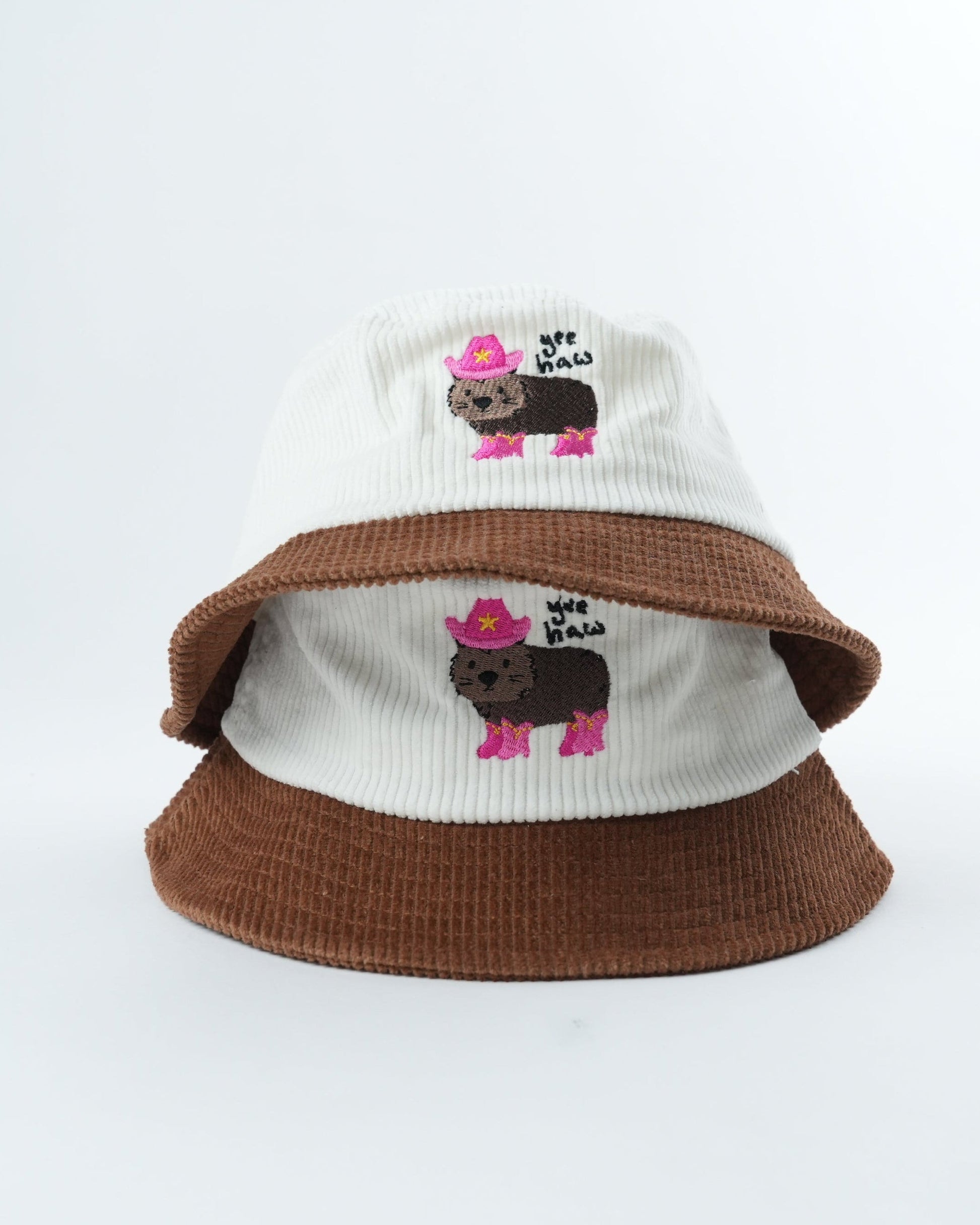 WOMBAT Wrangler bucket hat, white knit top and brown brim with pink wombat patches
