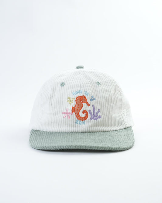 White ribbed baseball cap with light green brim and colorful seahorse front patch