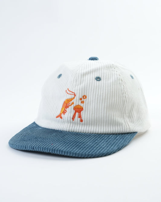 White mini cap with blue brim, orange shrimp and two blue dot accents
