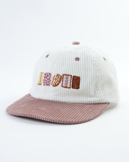 Knit cap with 'AUSSIE' letter patch and ribbed mauve brim, side view