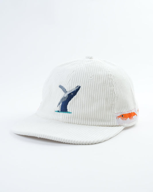 White cap angled view with embroidered whale graphic and orange fish side patch