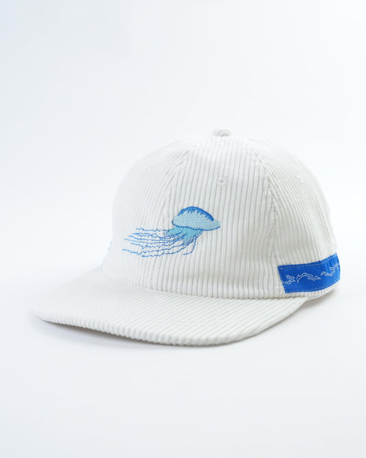 White ribbed baseball cap with blue bird front patch and side logo band