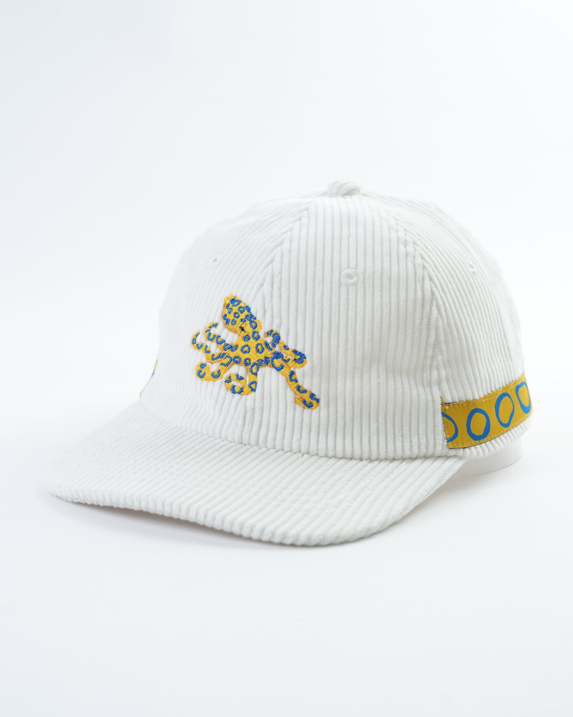 White ribbed cap with octopus patch and blue side text