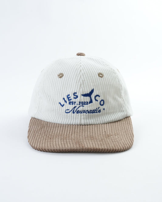 Two-tone baseball cap with white ribbed crown, brown brim, embroidered whale logo