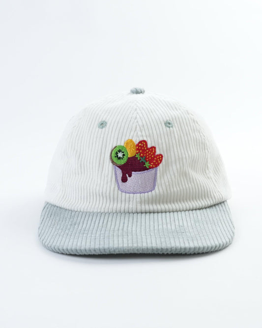 White cap with light blue brim and colorful acai bowl patch