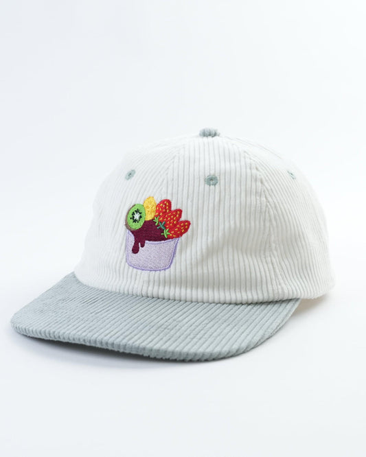 White cap with light blue brim and acai bowl patch on front, side view