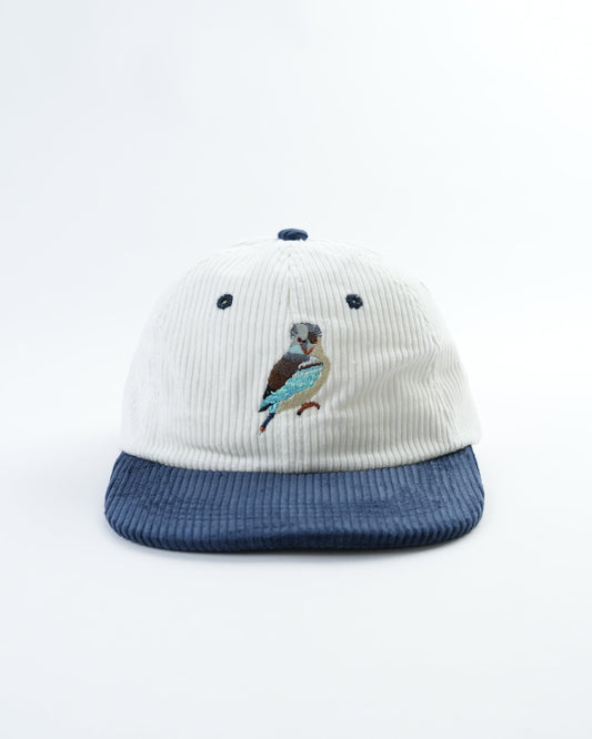 Vintage kookaburra cap with white ribbed crown, navy eyelets, and bird patch front