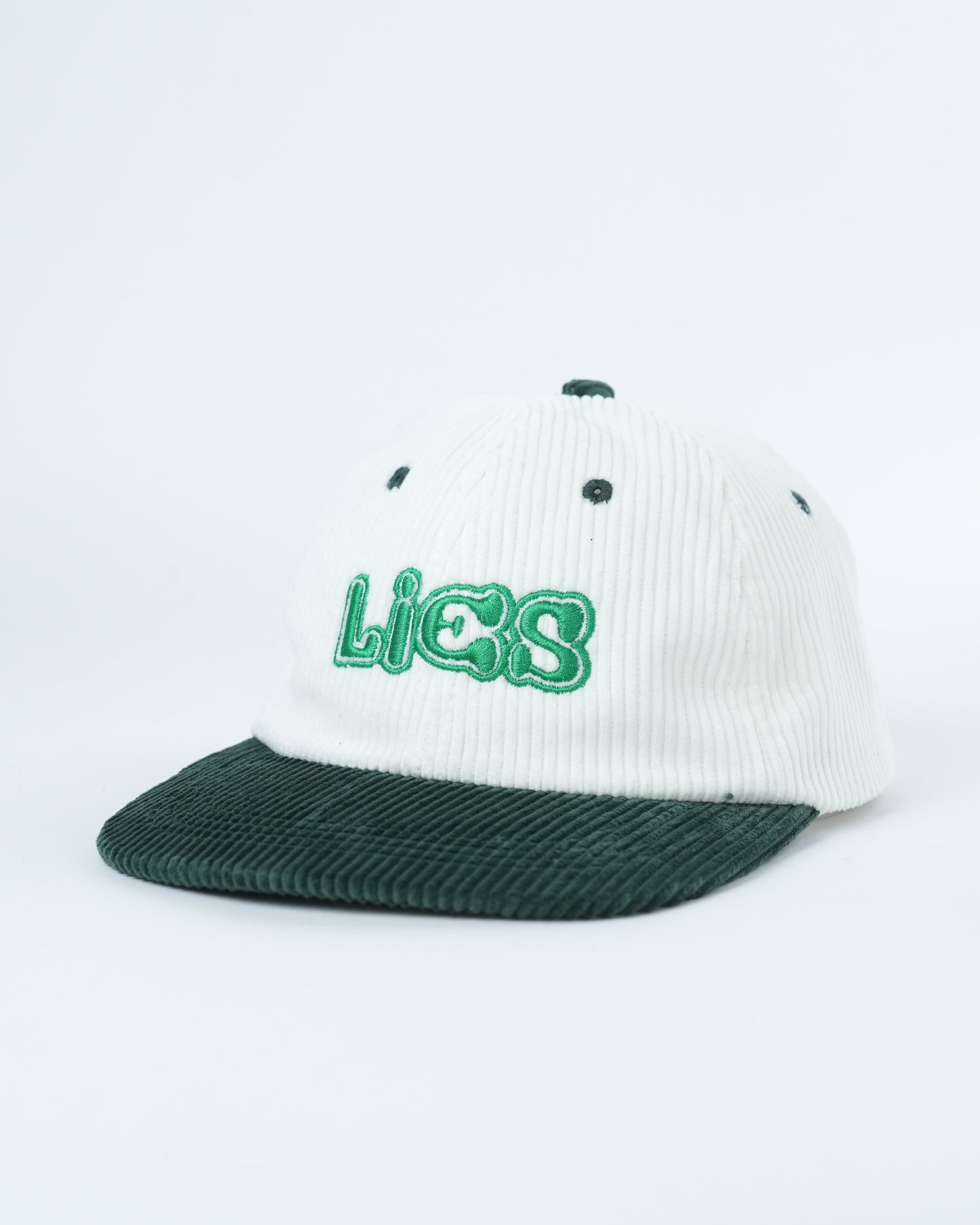 White ribbed baseball cap with dark green brim and green Lies logo front
