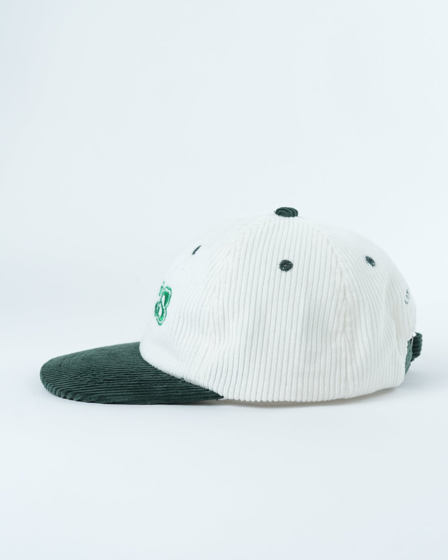 White ribbed baseball cap with dark green brim and small green side logo