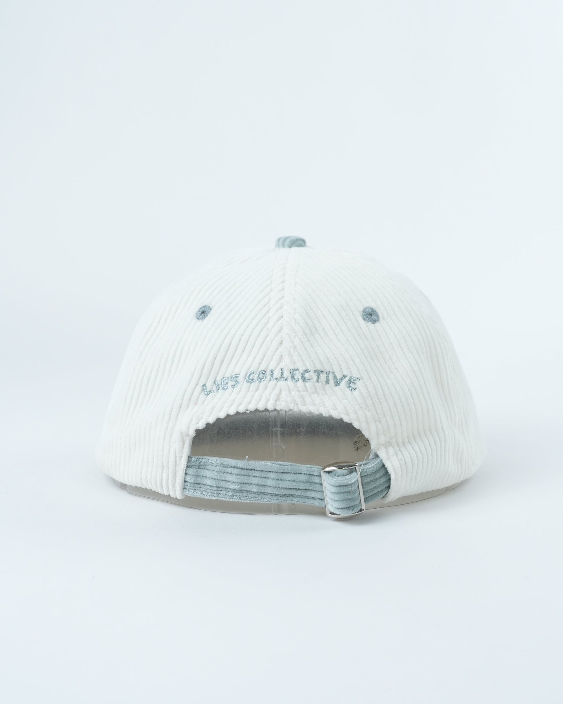 White corduroy baseball cap, interior view with striped lining and adjustable strap