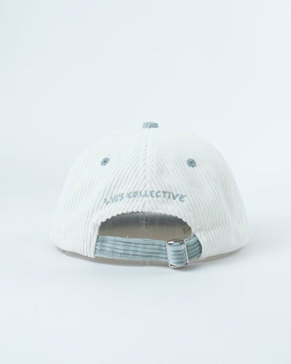 White corduroy baseball cap, interior view with striped lining and adjustable strap