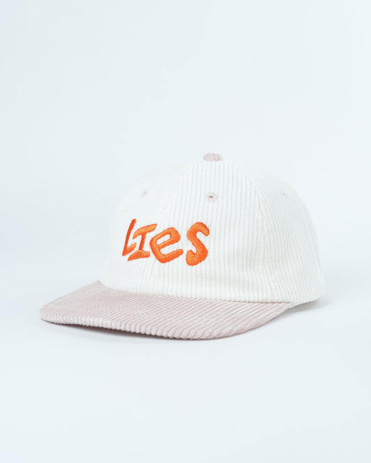 White ribbed knit cap with orange “Lies” logo and light pink brim