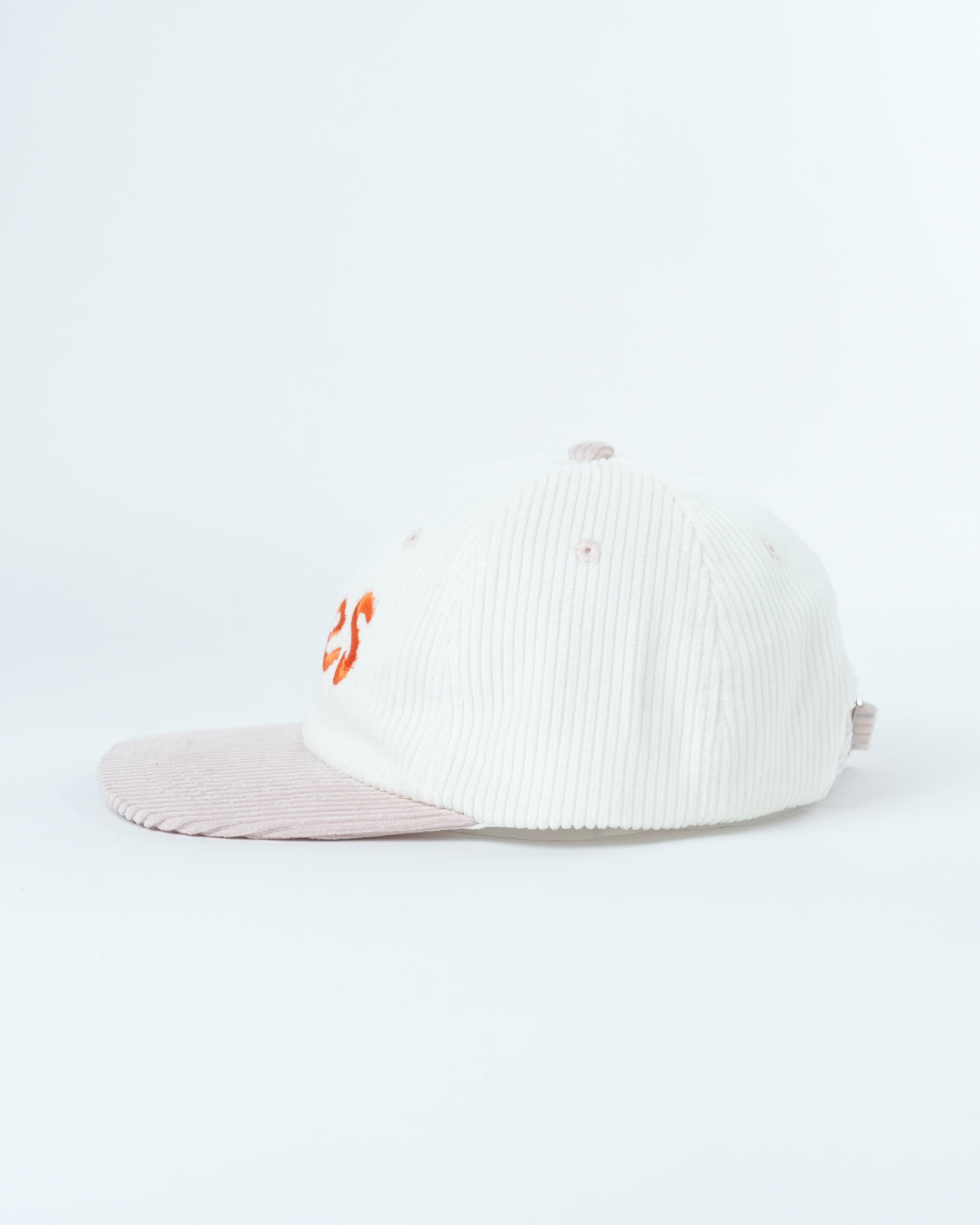 White ribbed knit cap with small orange side logo and light pink brim