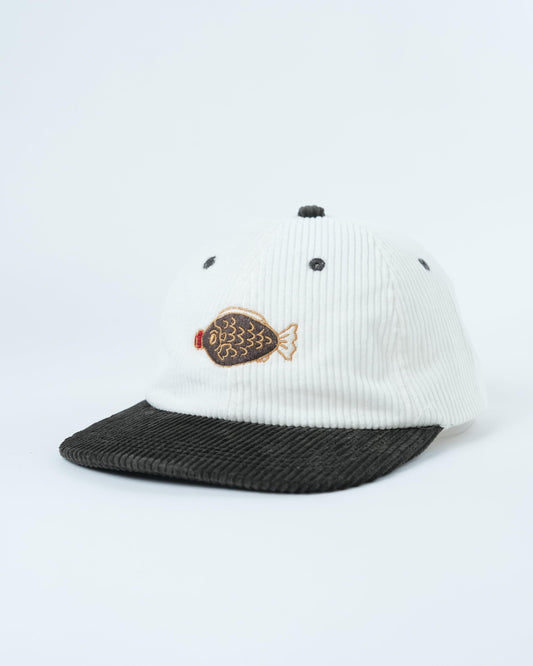 White ribbed baseball cap with dark brim, fish patch side and small dot accents