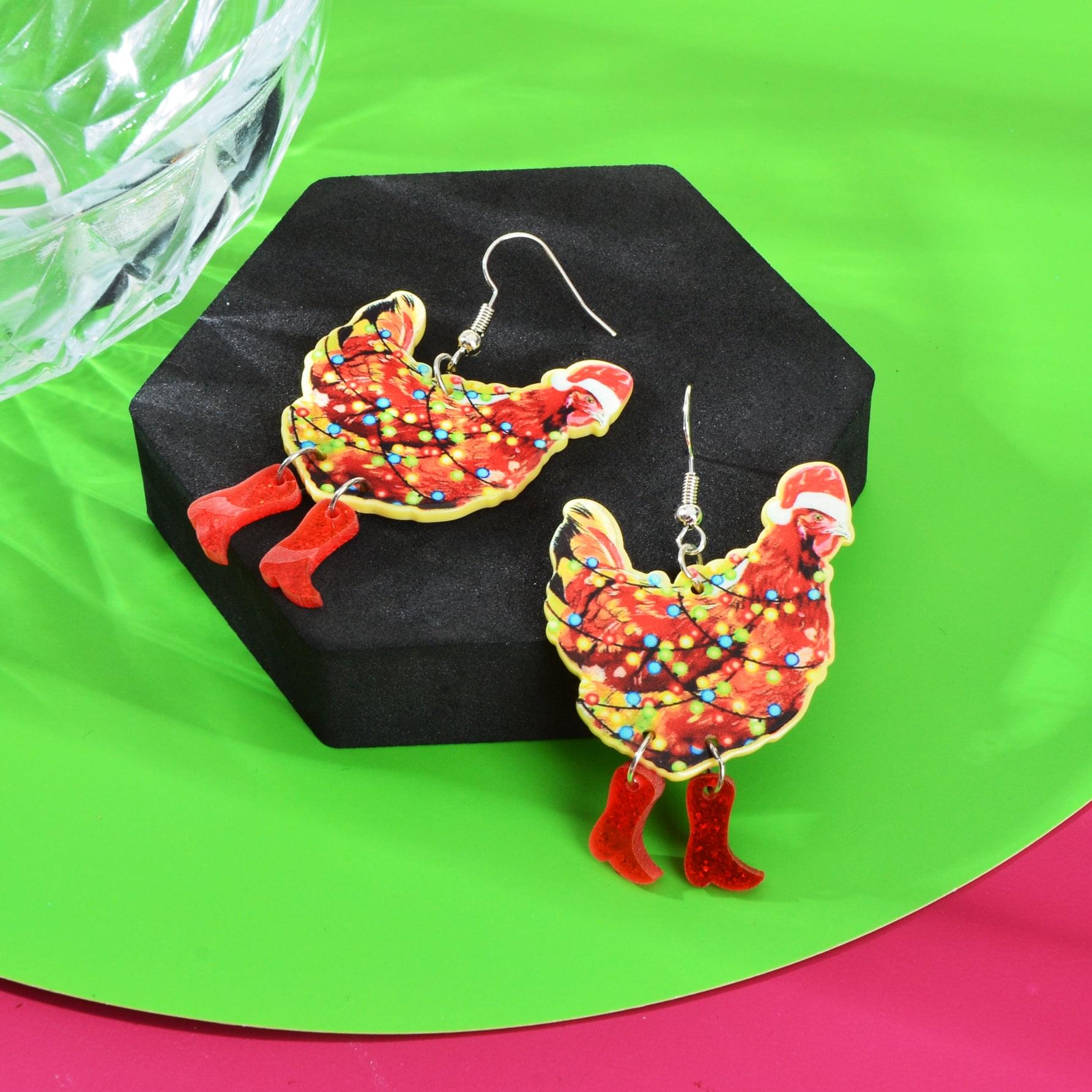 Santa-themed acrylic dangle earrings with colorful speckled pattern, red boots, hooks