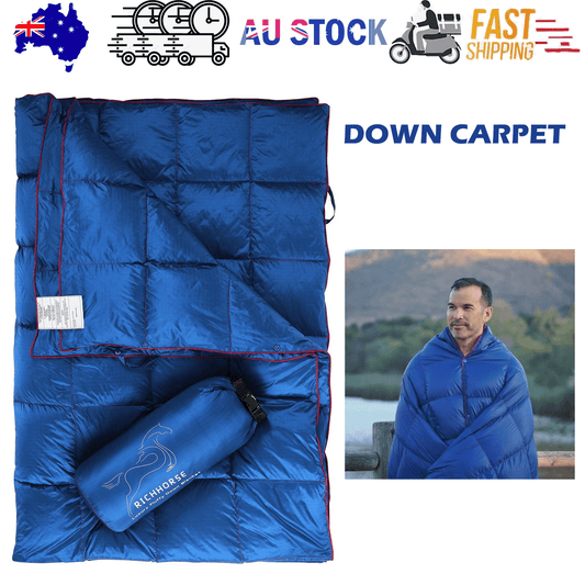 Packable blue down camping blanket, quilted with red trim and included stuff sack