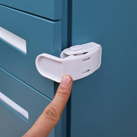 White childproof drawer lock attached to cabinet drawer front