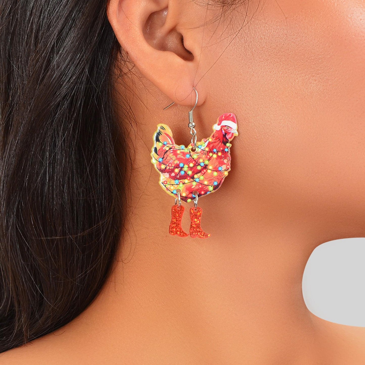 Santa acrylic dangle earrings worn on ear, red boots with multicolor light pattern