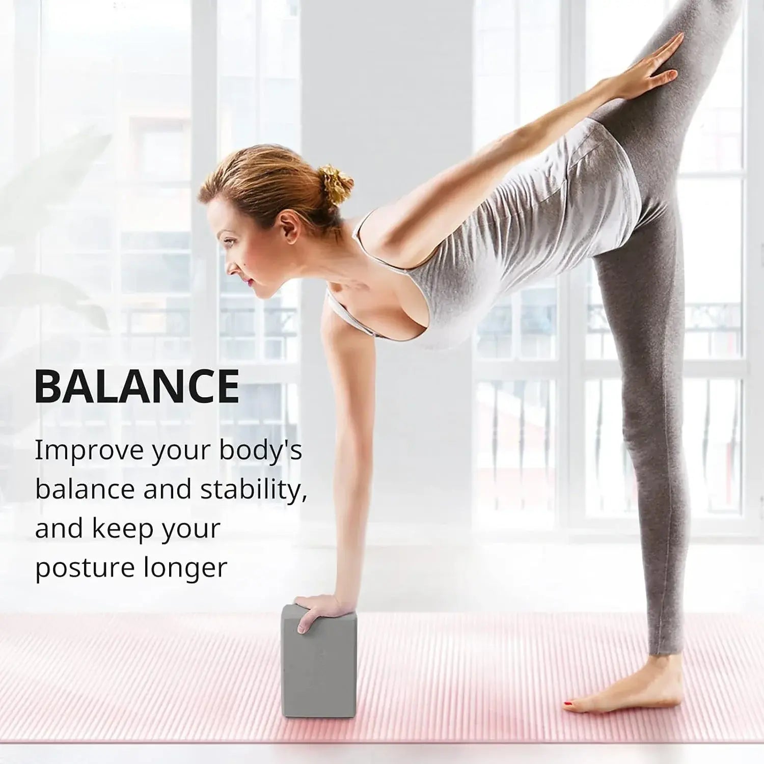 Grey foam yoga block under a standing yoga balance pose for stability