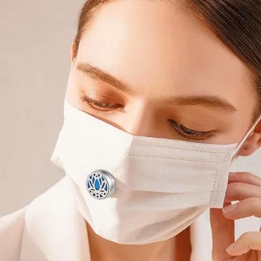 White face mask with round blue diffuser emblem