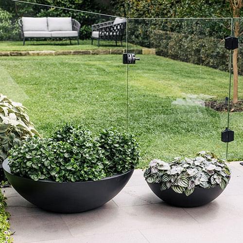 Black planter bowl with succulent arrangement on patio