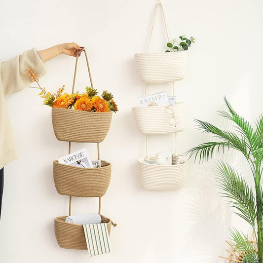 Tan woven hanging organizer with three baskets holding small items and flowers
