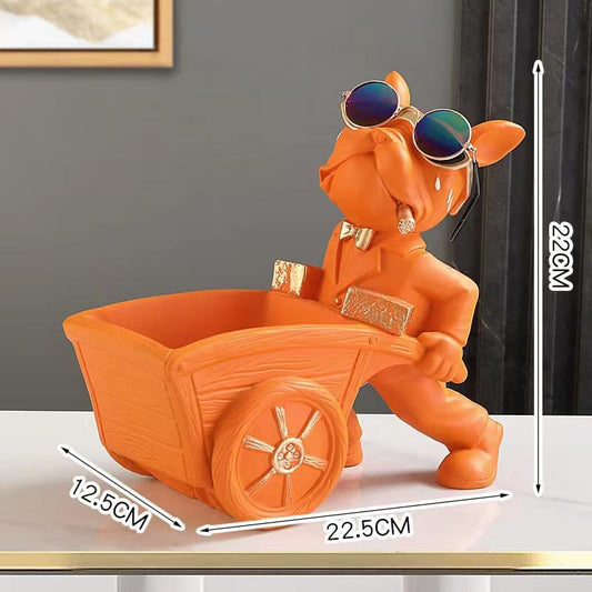 Orange resin bulldog key bowl figurine with sunglasses, pushing a wheelbarrow
