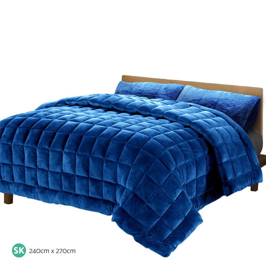 Blue faux mink quilt with diamond quilting and thick overhanging corners on a bed