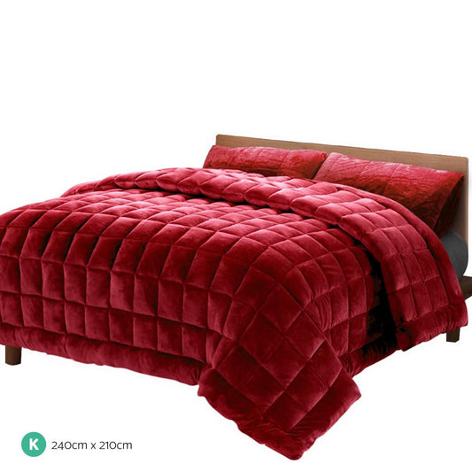 Burgundy faux mink king quilt folded over bed with plush blanket tail