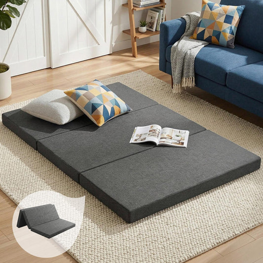 Grey foldable foam mattress laid out with blue patterned pillows